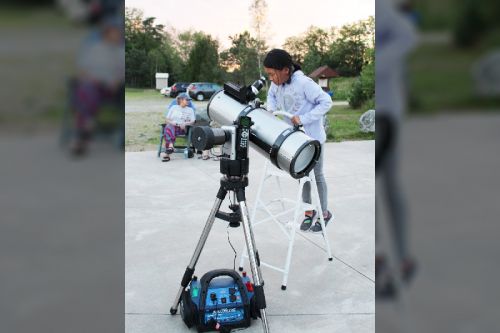 Si Si Yang from Ottawa helps Guy Nason align his 12-inch telescope at the Star Pad near Plevna Saturday night. Photo/Craig Bakay